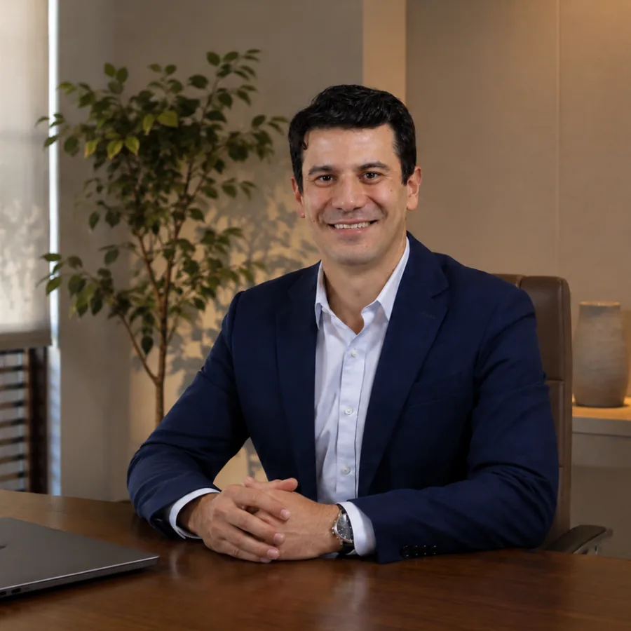 Dr. Henrique Cembranelli, cirurgião de mão e punho, sentado à mesa do consultório